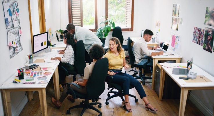 Webbdesignerteam samarbetar kring ett digitalt projekt på kontoret